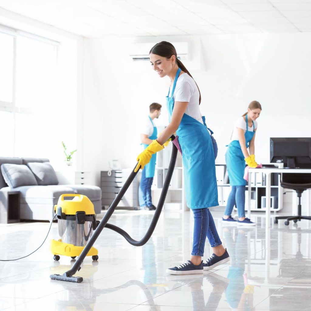 Three people cleaning an office