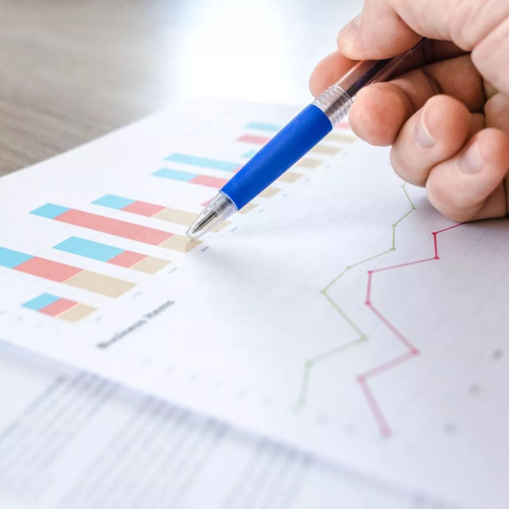 A pen on the page of a report with bar charts