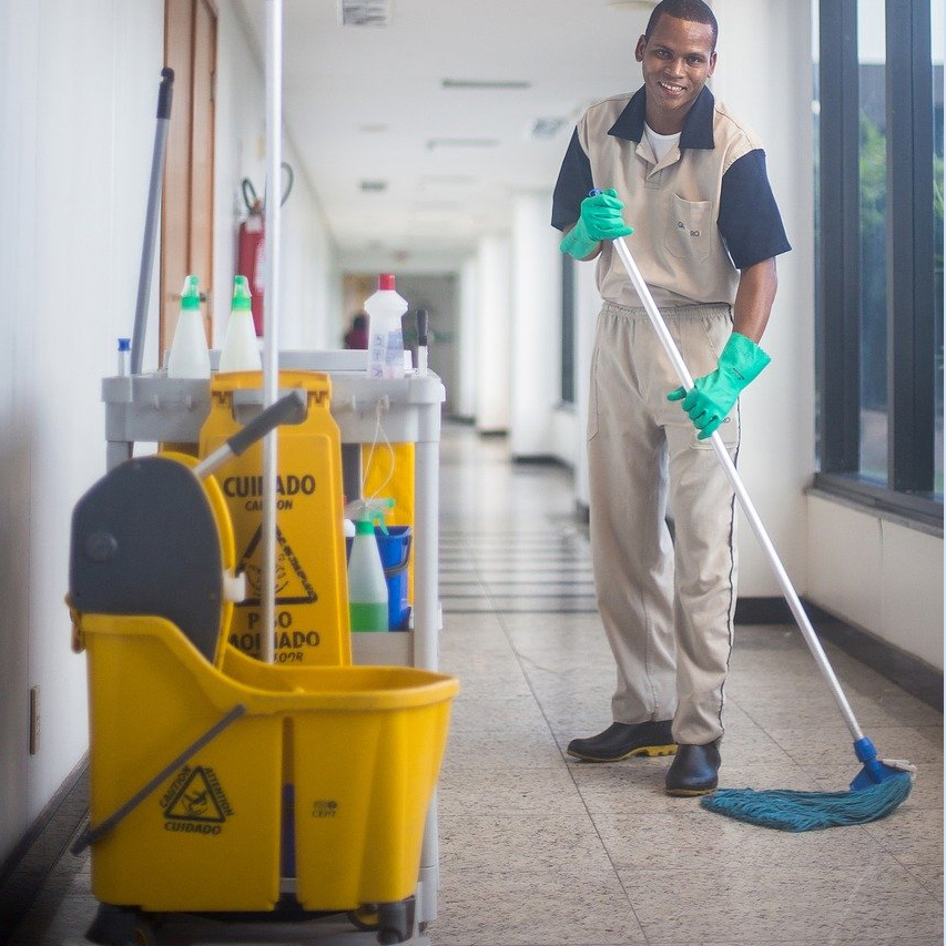 A cleaner mopping the corridor